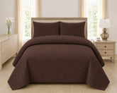 Brown quilted 3-piece bed spread set with two matching pillow shams on a made bed