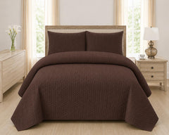 Brown quilted 3-piece bed spread set with two matching pillow shams on a made bed