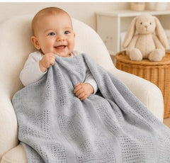 Baby wrapped in grey cellular cotton blanket