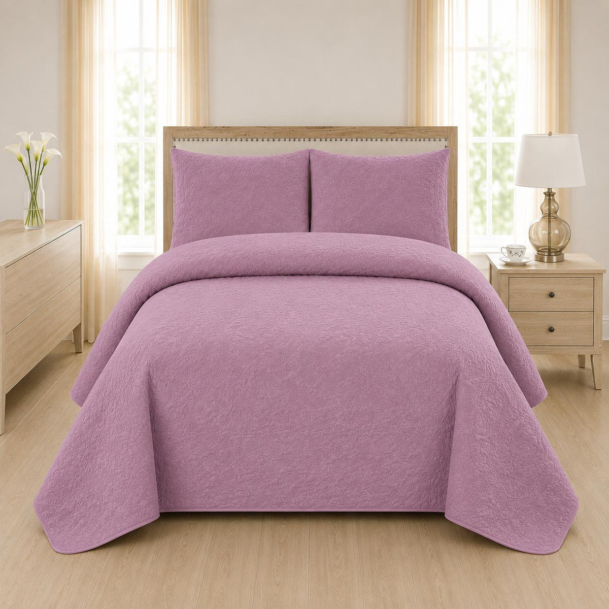 Mauve dusty pink quilted 3-piece bed spread set with two matching pillow shams on a made bed