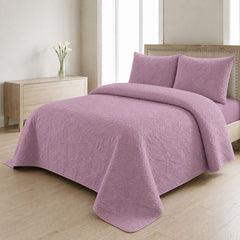 Mauve dusty pink quilted bedspread styled on a bed in a cosy neutral bedroom