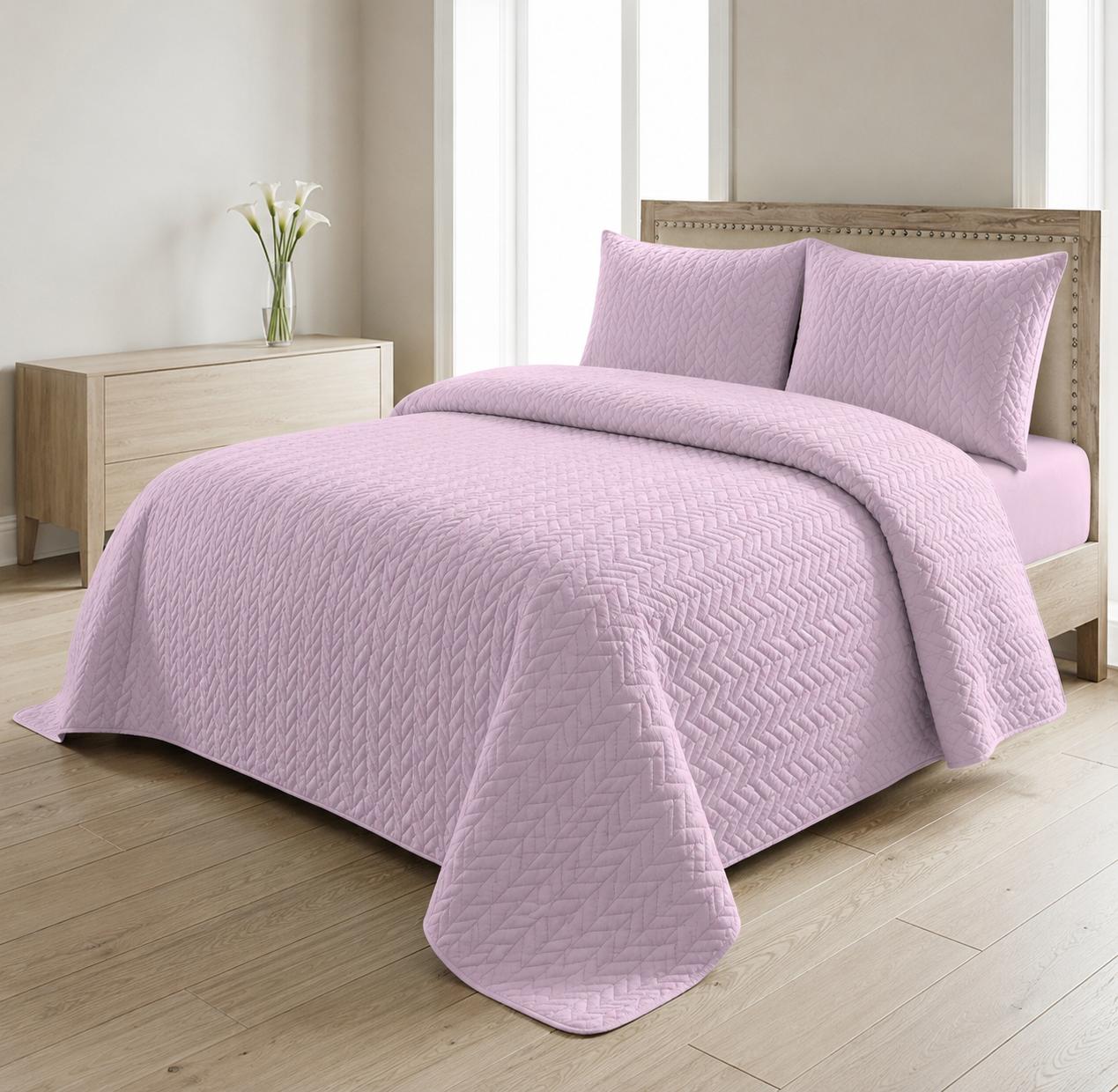 Lilac quilted 3-piece bed spread set with two matching pillow shams on a made bed