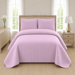 Lilac quilted bedspread styled on a bed in a cosy neutral bedroom
