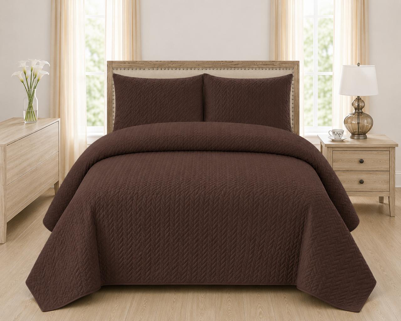 Brown quilted 3-piece bed spread set with two matching pillow shams on a made bed