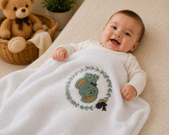 Baby using white embroidered woodland bunny cotton blanket by The Idea