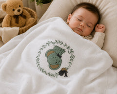 Sleeping baby under The Idea woodland bunny embroidered cotton blanket