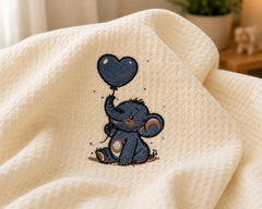 Close-up of elephant heart embroidery on cream cotton baby blanket