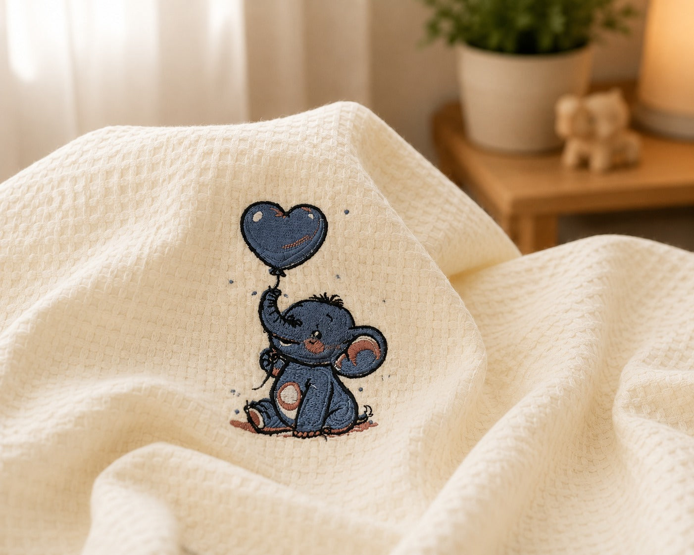 Detailed elephant and heart balloon embroidery on textured cotton baby blanket