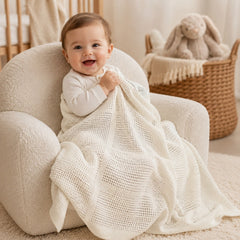 Baby wrapped in ivory cellular cotton blanket