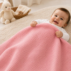 Baby wrapped in pink waffle cotton thermal blanket