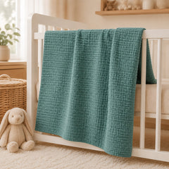 Teal waffle baby thermal blanket on a crib