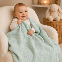 Baby wrapped in mint basketweave cotton blanket