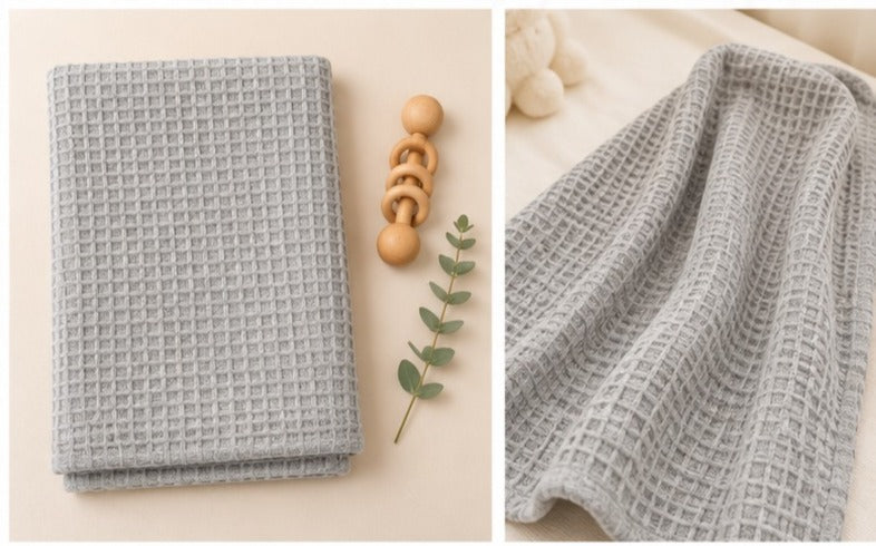 Light grey honeycomb waffle cotton baby blanket, folded and close up