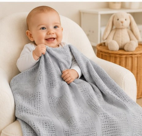 Baby wrapped in grey cellular cotton blanket
