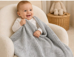 Baby wrapped in grey basketweave cotton blanket