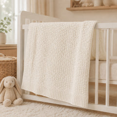 Ivory waffle baby thermal blanket on a crib