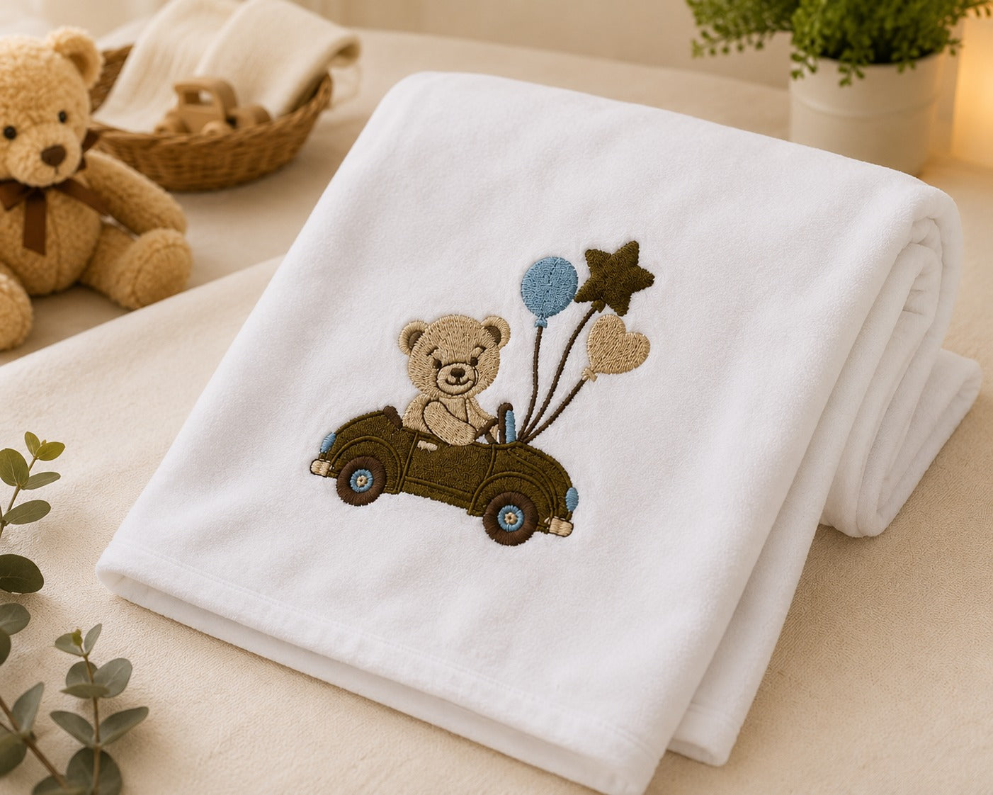 Folded white cotton baby blanket with teddy bear car embroidery