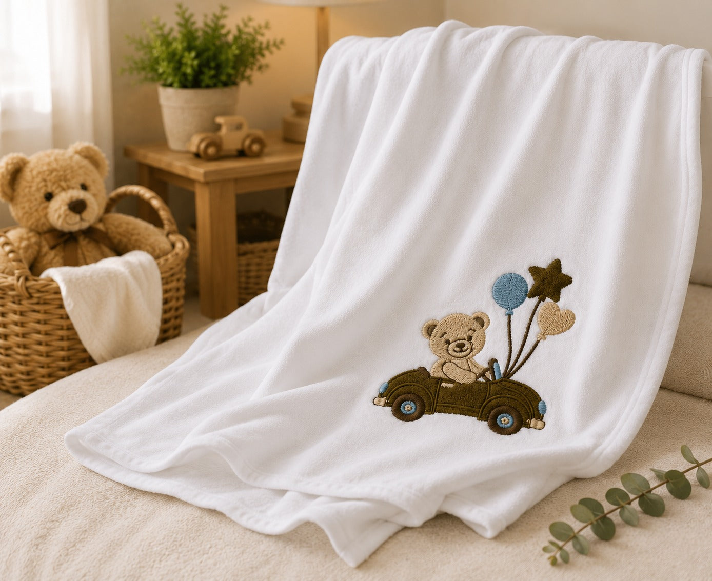 Teddy bear embroidered baby blanket displayed in nursery setting
