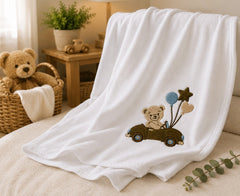 Teddy bear embroidered baby blanket displayed in nursery setting
